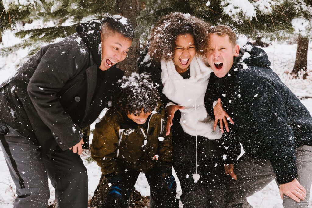 Family making fun faces in a snowy moment